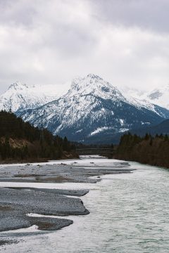 自然纪录片《地球四季》封面，航拍雪山与森林交界处的壮观景色，画面冷峻辽阔大气磅礴